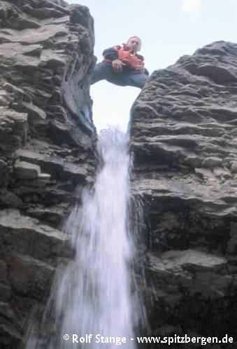 Waterfall cascading down hard carbonate layers of the Kapp Starostin Formation in western Dickson Land