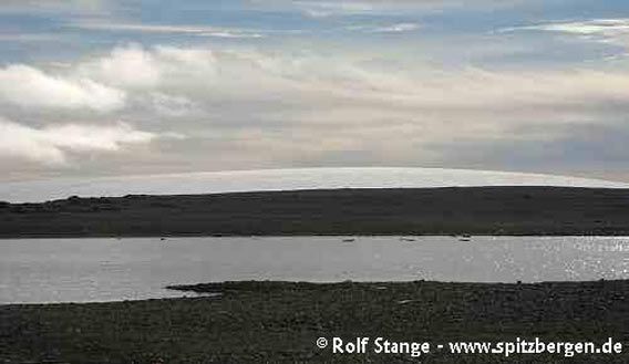 Storøya. A lake in the barren tundra and the ice cap in the background.