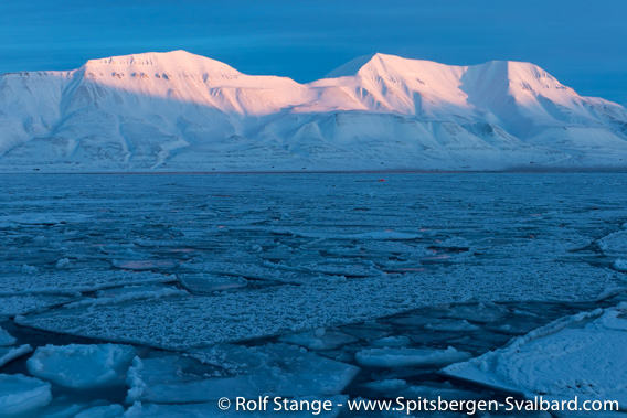 Ice in Adventfjord and sun on the mountains